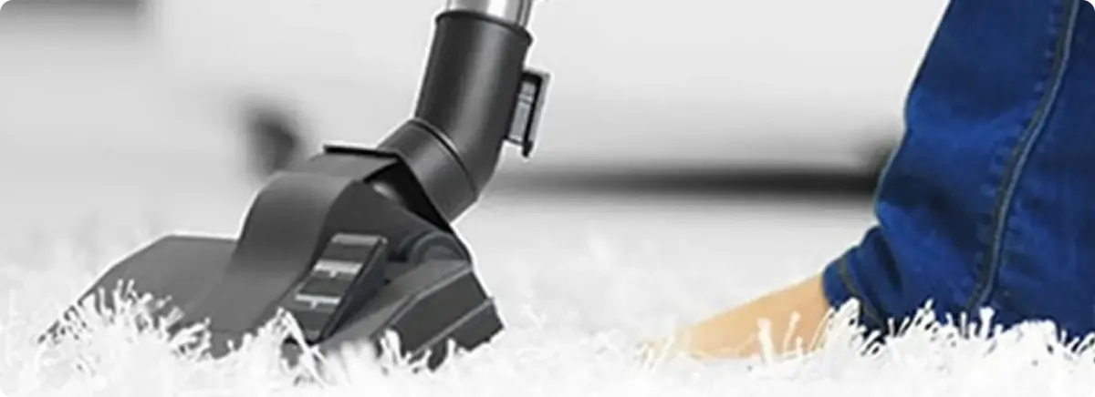 Close-up of a professional vacuuming a white carpet in Santa Teresa.